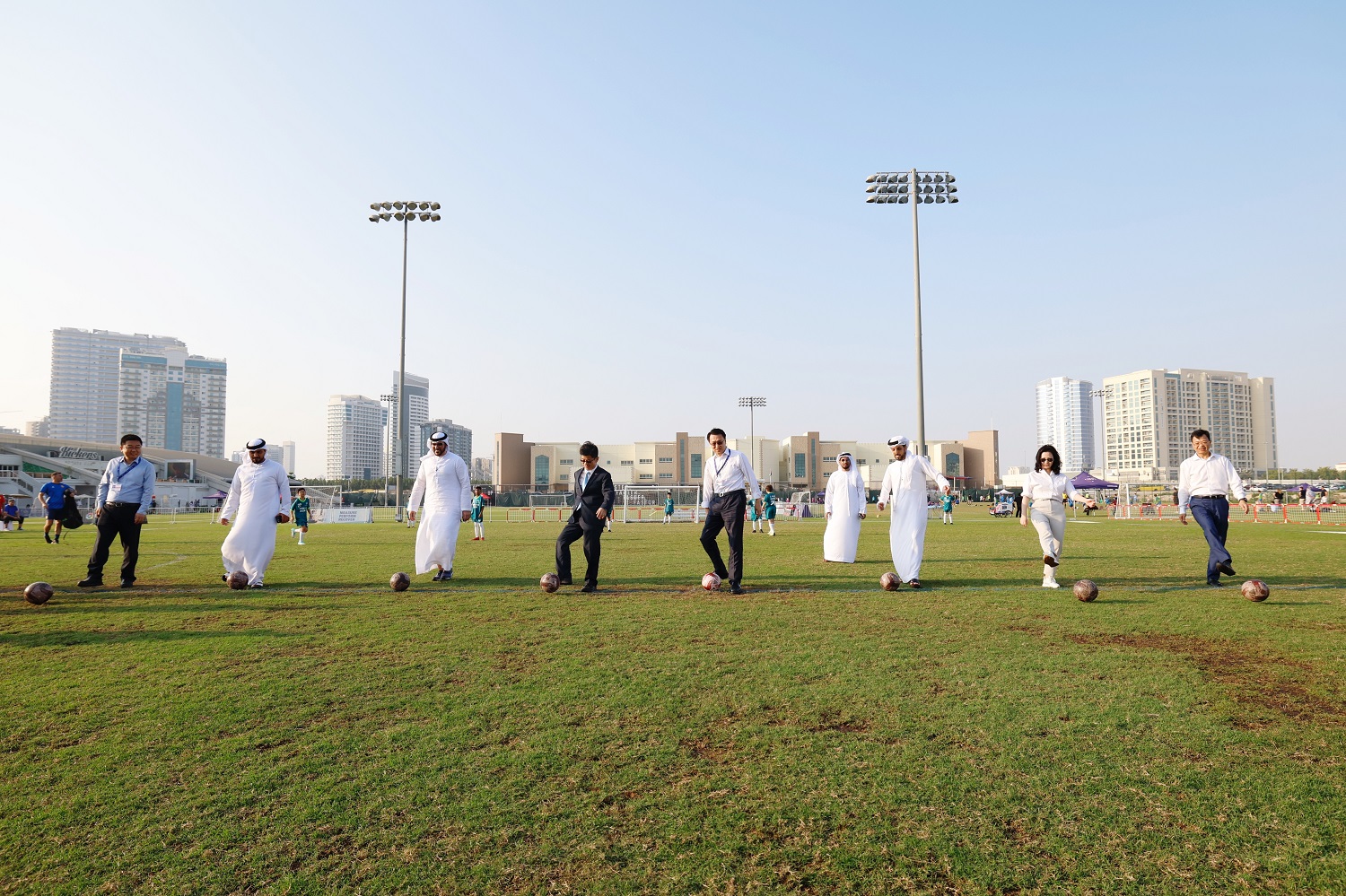 Participating guests perform the kick-off for the football match. (Photo/China News Service)