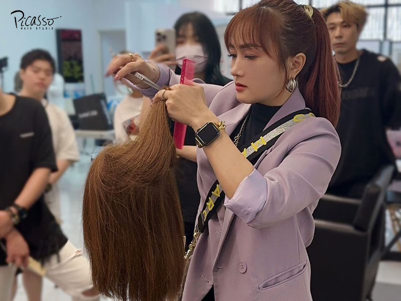 Hairstylist teaching precision haircut to students